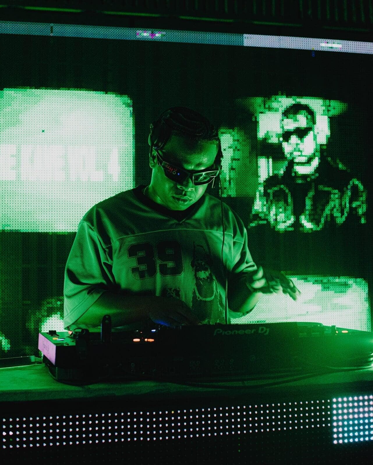 Image of DJ with sunglasses at the DJ board
